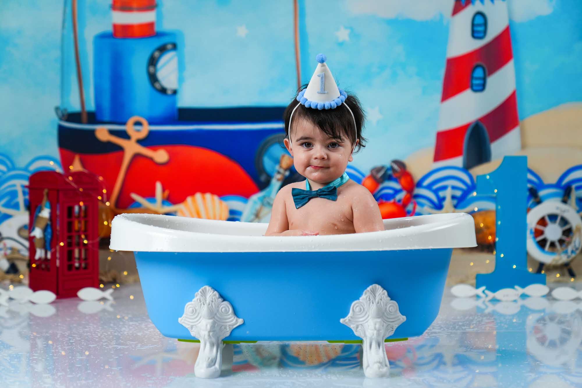 Baby im blauen Geburtstags-Badewannen-Set mit maritimer Dekoration – Cake Smash Studio Wien