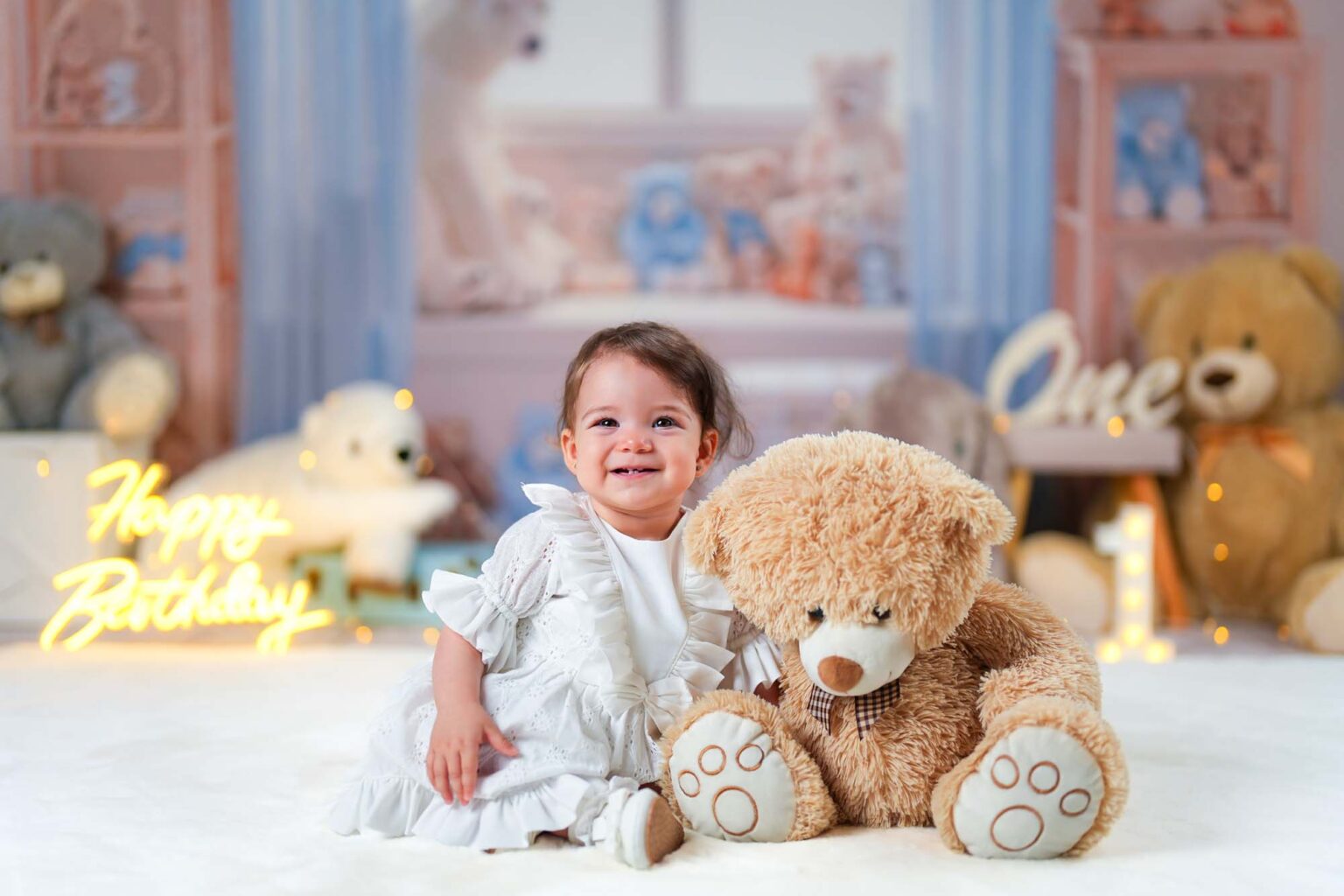 Mädchen im weißen Kleid neben einem großen braunen Teddybären.