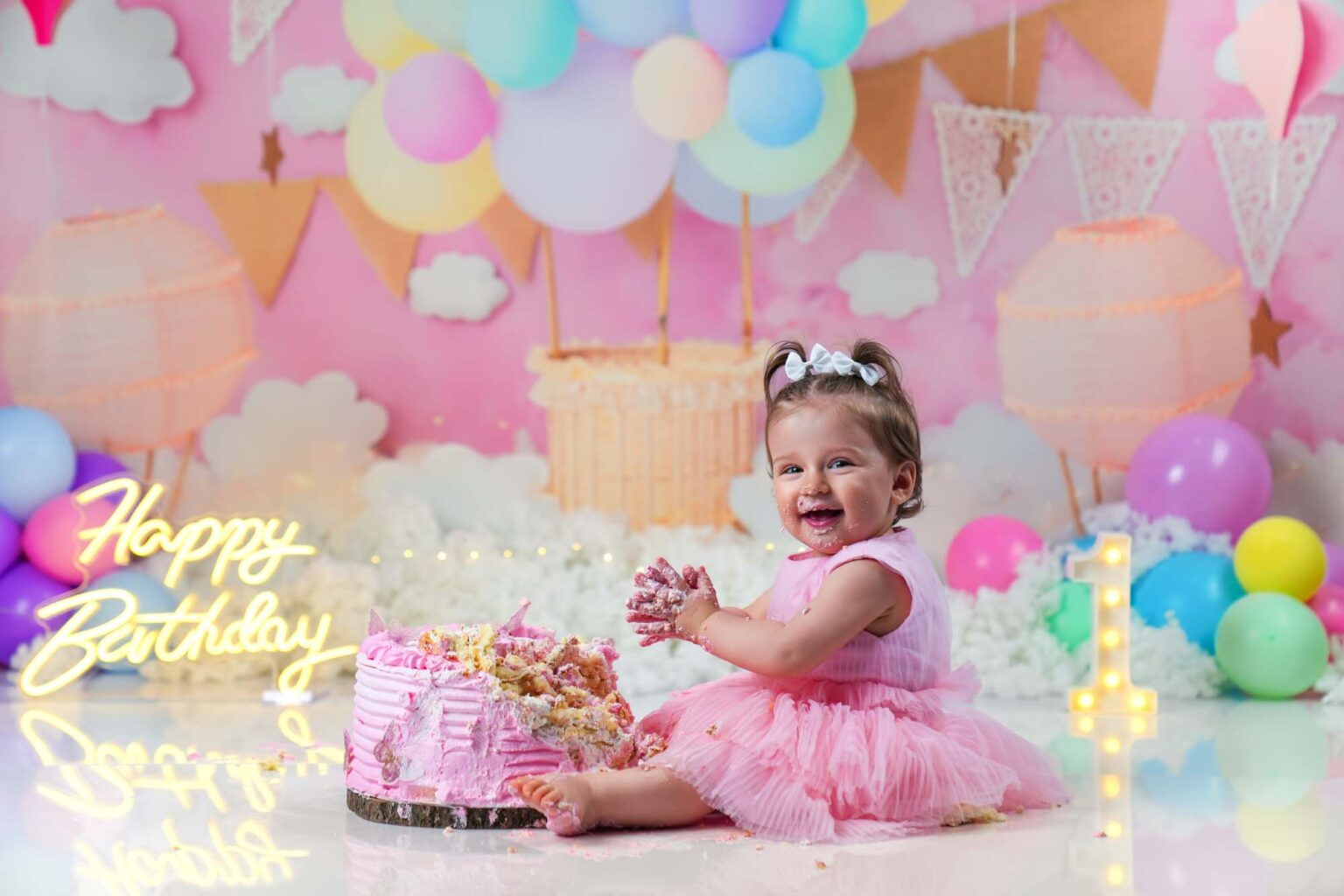 Baby im rosa Kleid beim Cake Smash Shooting mit pinker Geburtstagstorte in Wien
