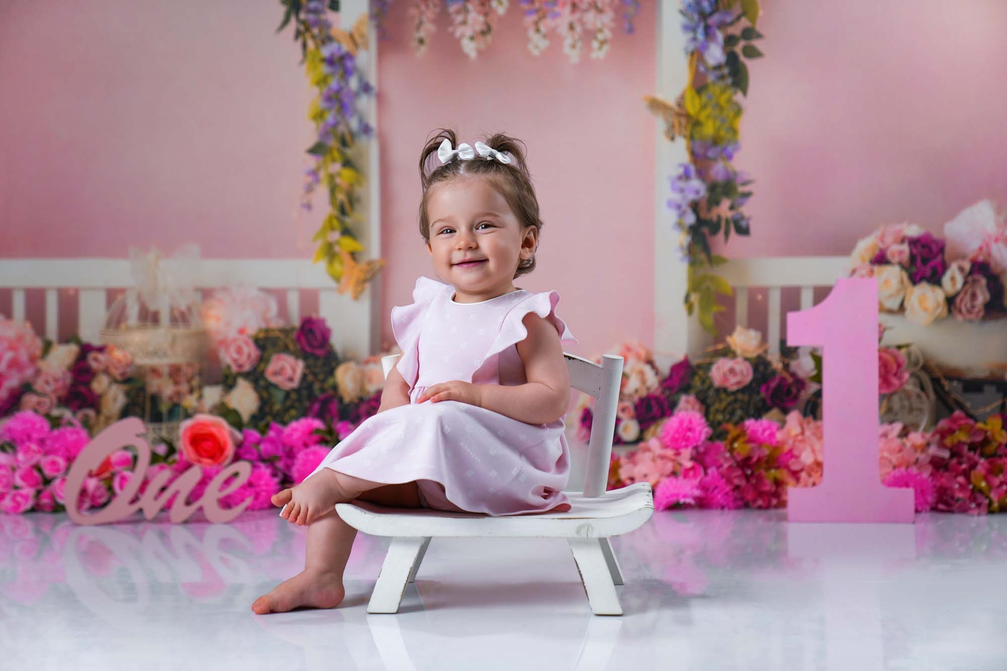 Baby im rosa Kleid auf kleinem weißen Stuhl beim ersten Geburtstagsshooting in Wien