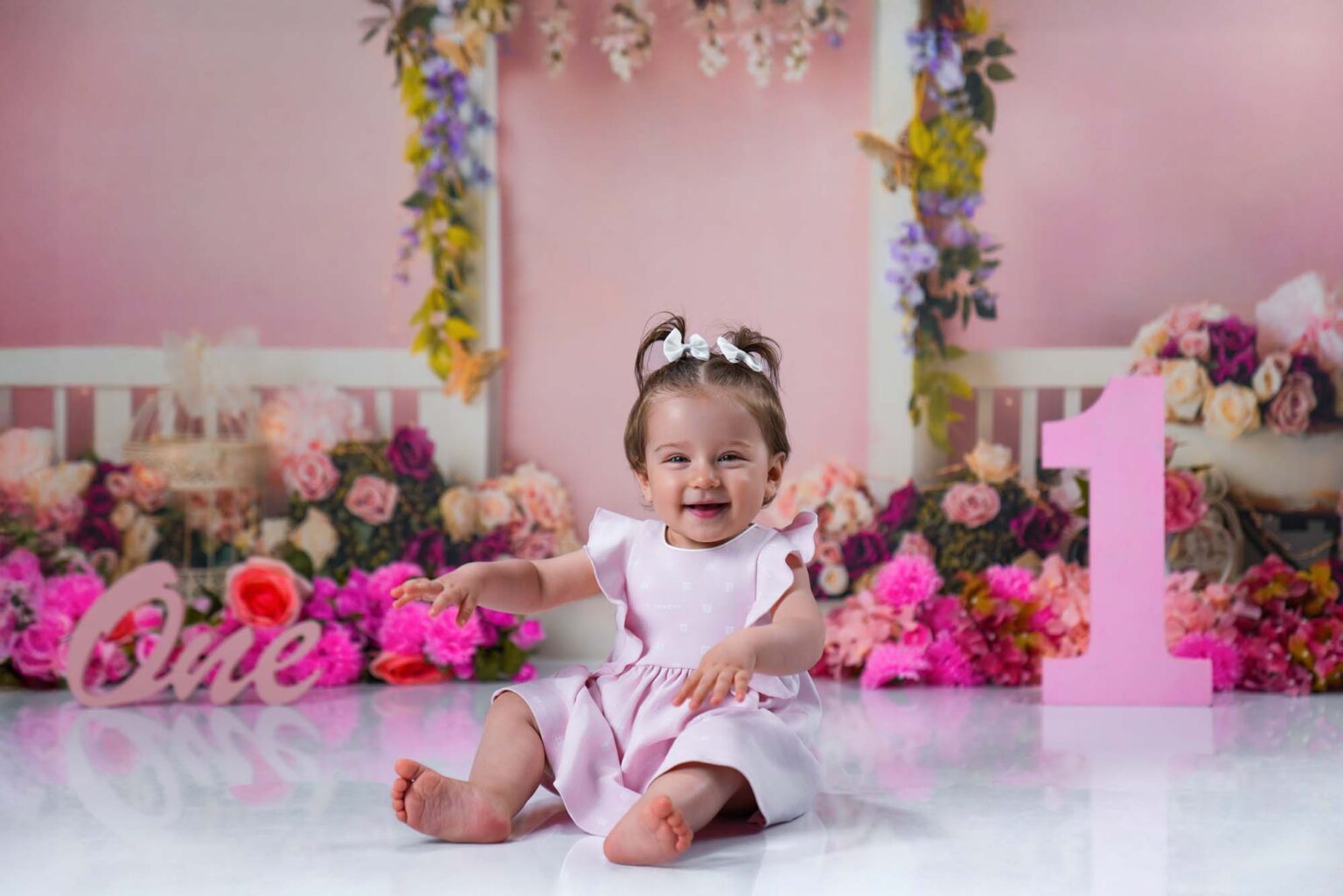 Baby im rosa Kleid beim ersten Geburtstagsshooting mit Blumendekoration in Wien