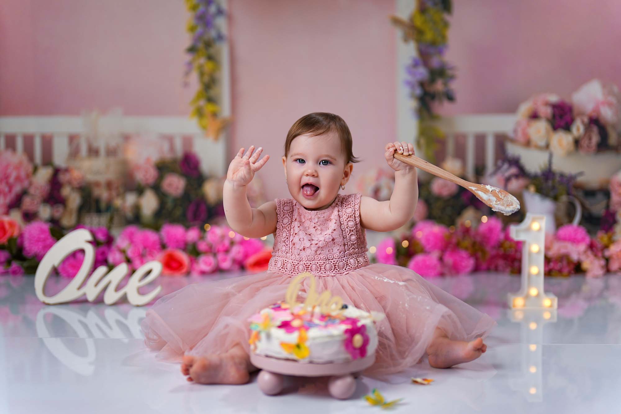 Baby im rosa Tüllkleid beim fröhlichen Cake Smash Shooting in Wien